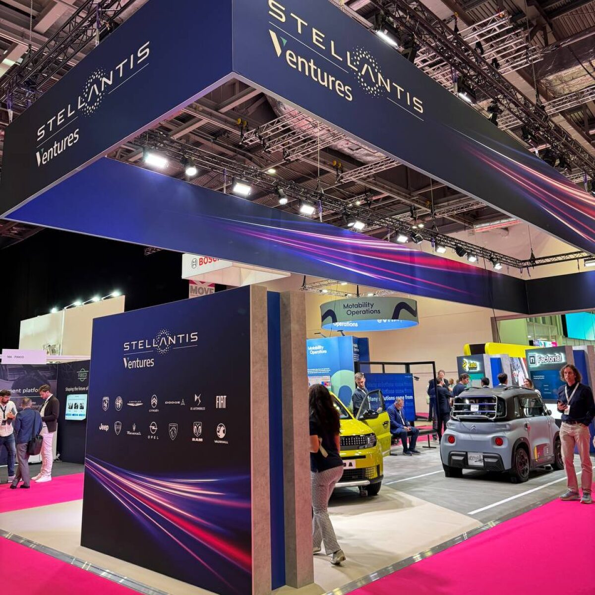 Exhibition scene at MOVE 2025: booth, vehicles, and visitors